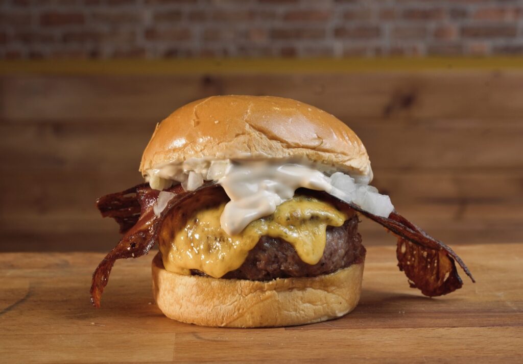 Hamburguesa a la brasa con bacon, queso cheddar, cebolla y smoked mayo