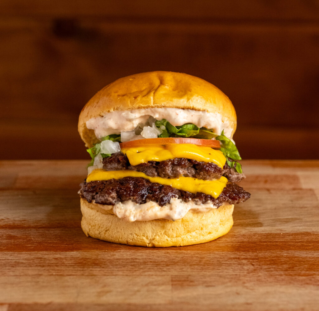 Hamburguesa doble con queso americano, lechuga, cebolla, tomate y salsa de la casa