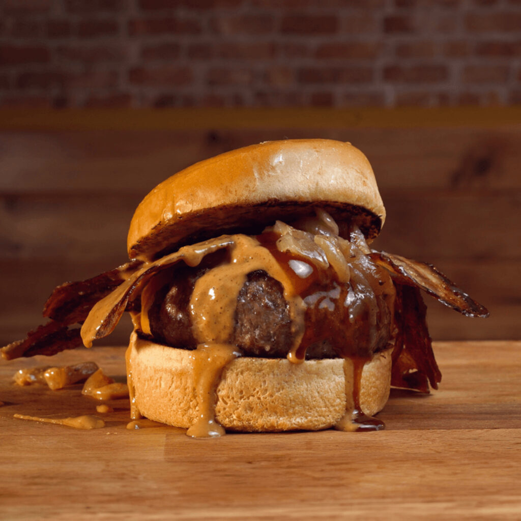 Hamburguesa de carne a la brasa, queso cheddar, cebolla caramelizada, bacon, peanut butter (mantequilla de cacahuete) y un toque de salsa BBQ en Madrid