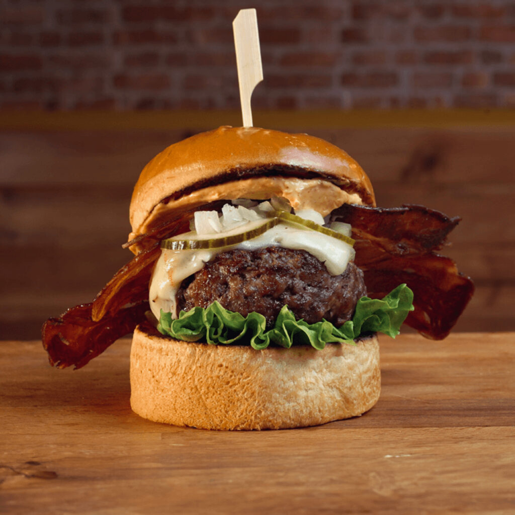Hamburguesa de carne a la brasa, queso Monterrey Jack, bacon, lechuga, jalapeños, aros de cebolla y barbacoa en Madrid